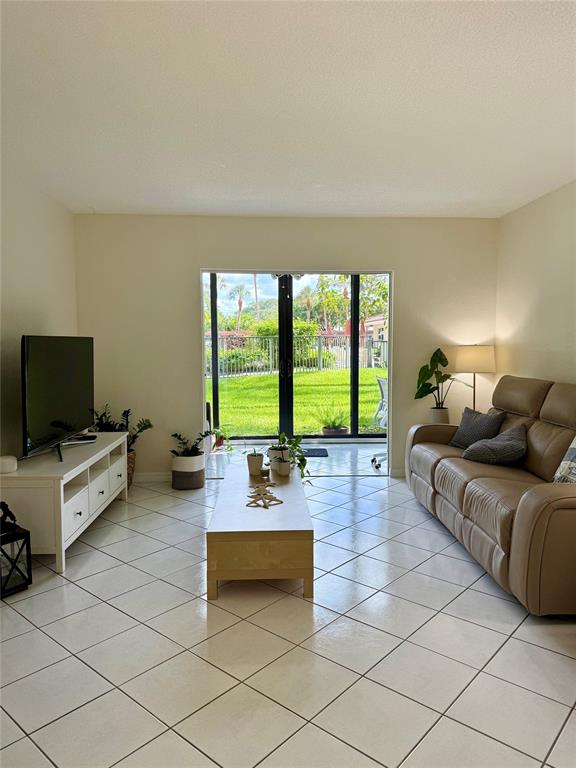 2350 Northeast 14th Street Causeway, Unit 108 Pompano Beach, FL 33062 - Photo 6 of 38 a living room with furniture and a flat screen tv