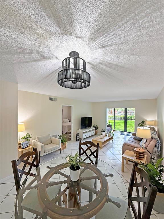 2350 Northeast 14th Street Causeway, Unit 108 Pompano Beach, FL 33062 - Photo 8 of 38 a view of a dining room with furniture a livingroom and chandelier