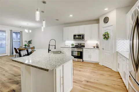 a kitchen with stainless steel appliances granite countertop a sink stove and refrigerator