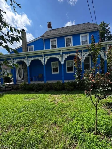 a view of a brick house with a yard and plants