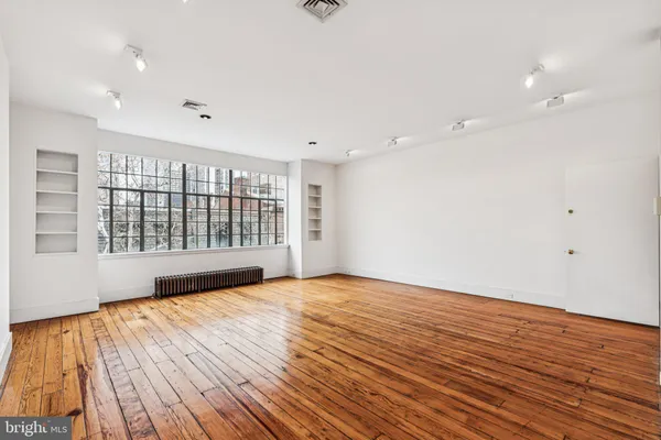 a view of an empty room with wooden floor