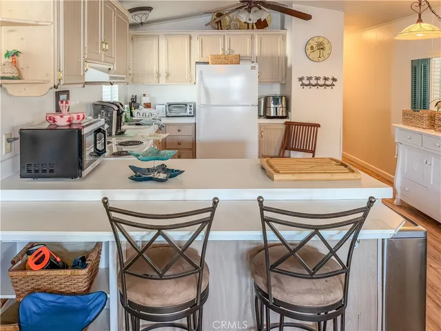 a kitchen with stainless steel appliances granite countertop a dining table and chairs