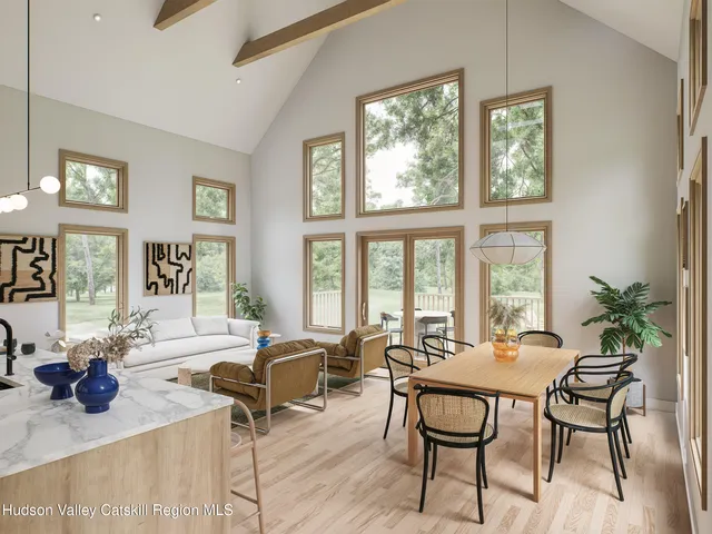 a living room with furniture a large window and potted plants