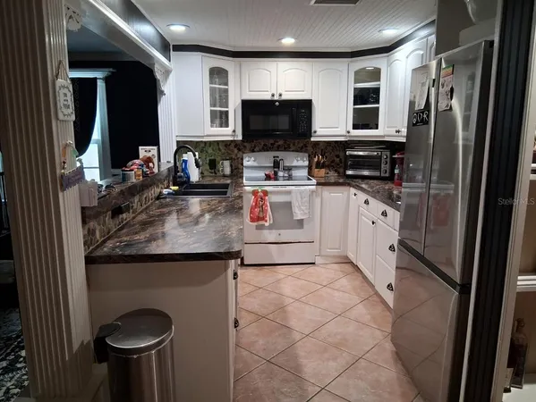 a kitchen with a refrigerator and a stove top oven