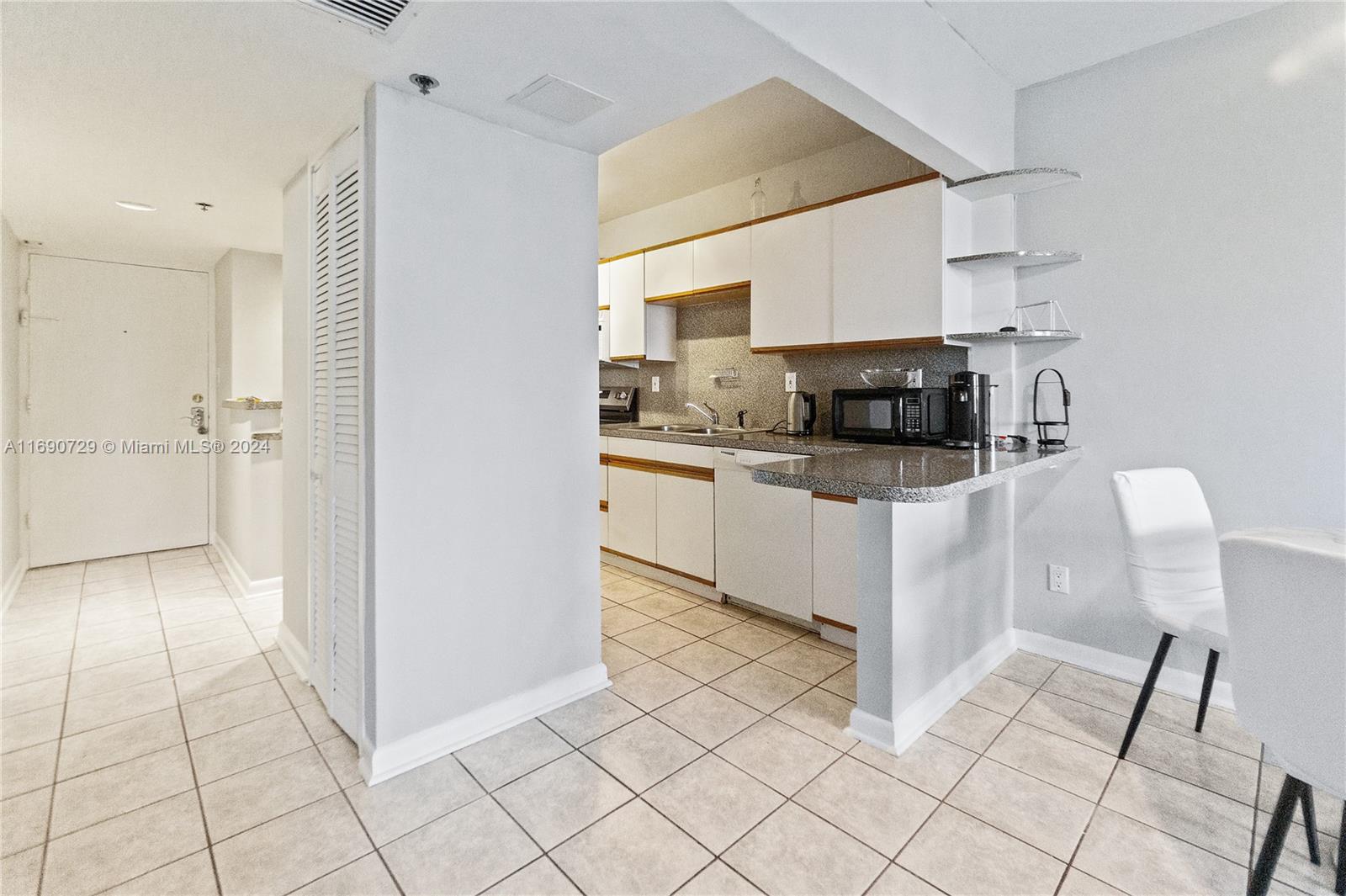 100 Lincoln Road, Unit 1019 Miami Beach, FL 33139 - Photo 5 of 16 a kitchen with stainless steel appliances kitchen island granite countertop a refrigerator and a stove top oven