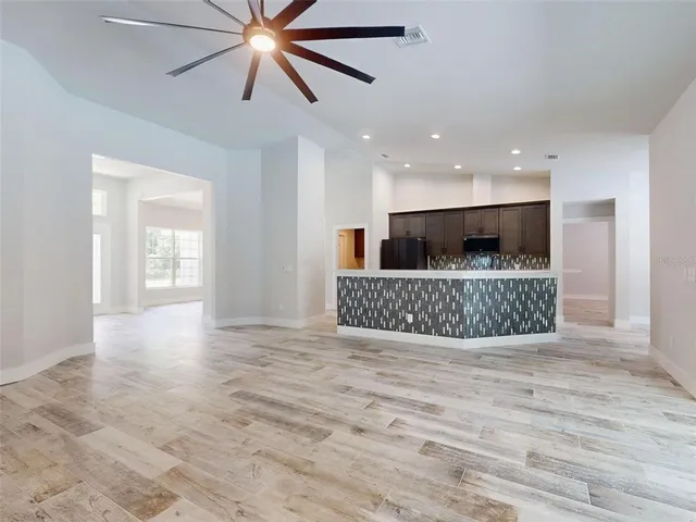a view of empty room with wooden floor and a window