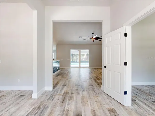 a view of an empty room with window and wooden floor