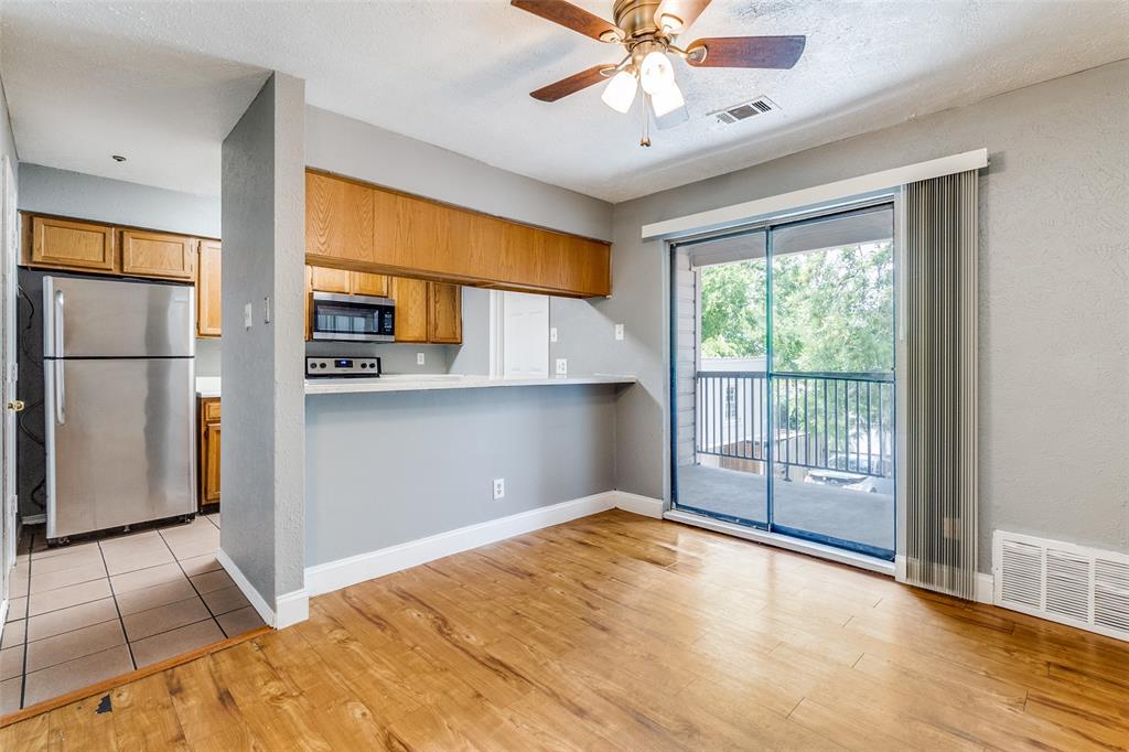 2354 Little Pocket Road, Unit B Dallas, TX 75228 - Photo 4 of 12 Kitchen with stainless steel appliances, light countertops, a ceiling fan, wood finish cabinetry, and light wood-type flooring