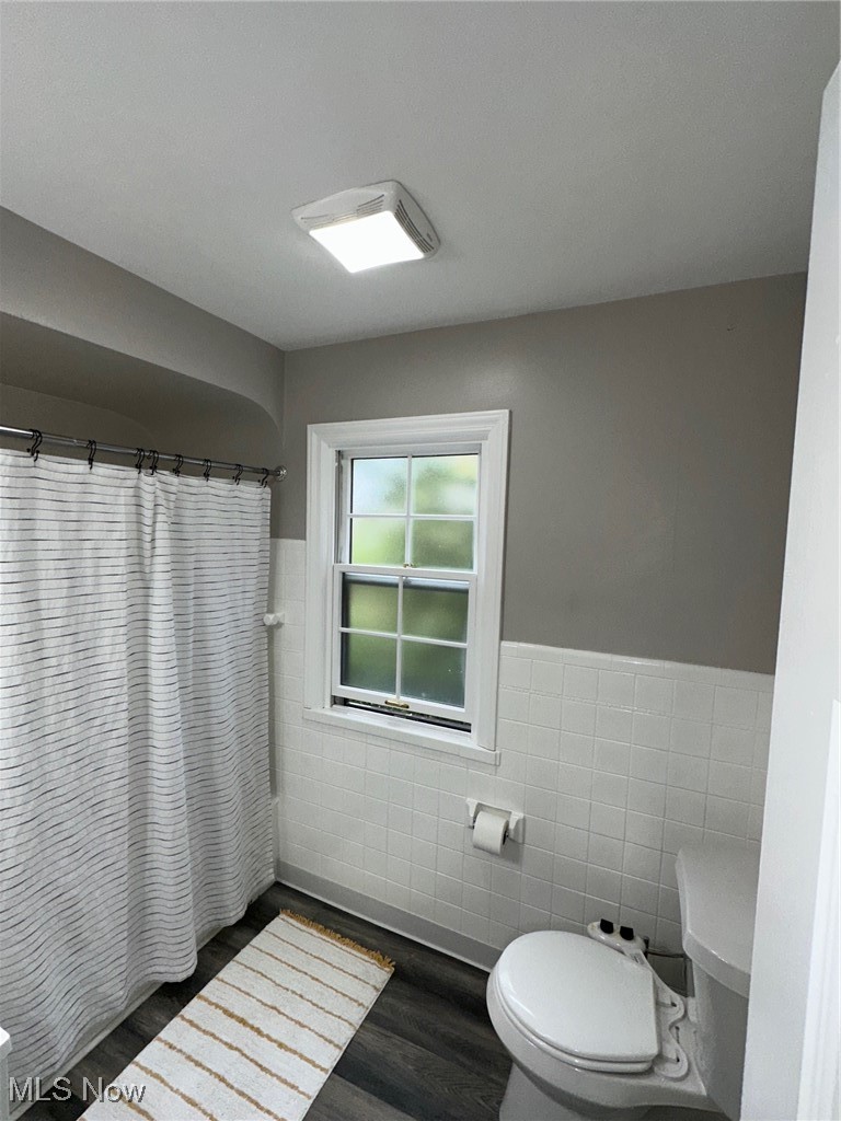 3498 Cummings Road Cleveland, OH 44118 - Photo 18 of 22 Full bathroom featuring tile walls, a wainscoted wall, a shower with shower curtain, and dark wood-style floors