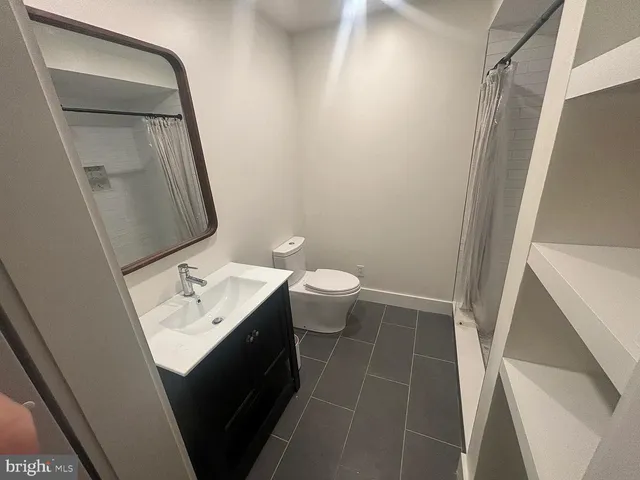 a bathroom with a toilet a sink and mirror