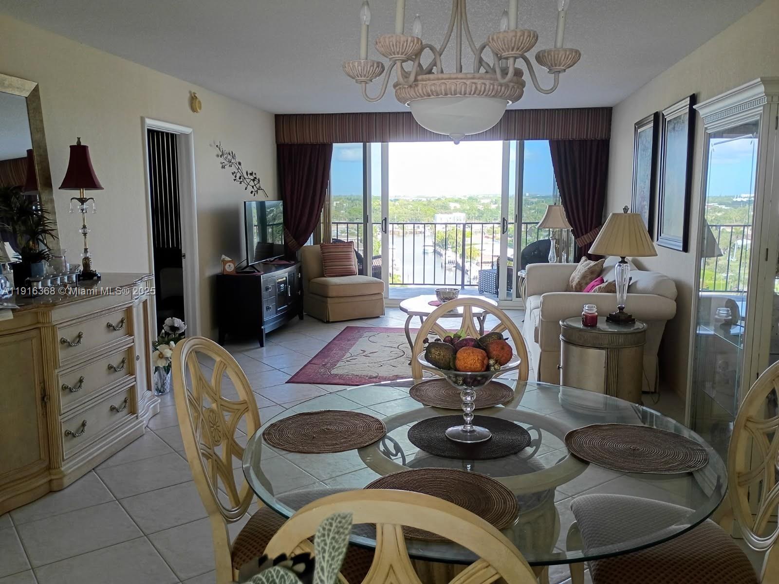 521 North Riverside Drive, Unit 907 Pompano Beach, FL 33062 - Photo 11 of 23 a living room with furniture chandelier and a large window