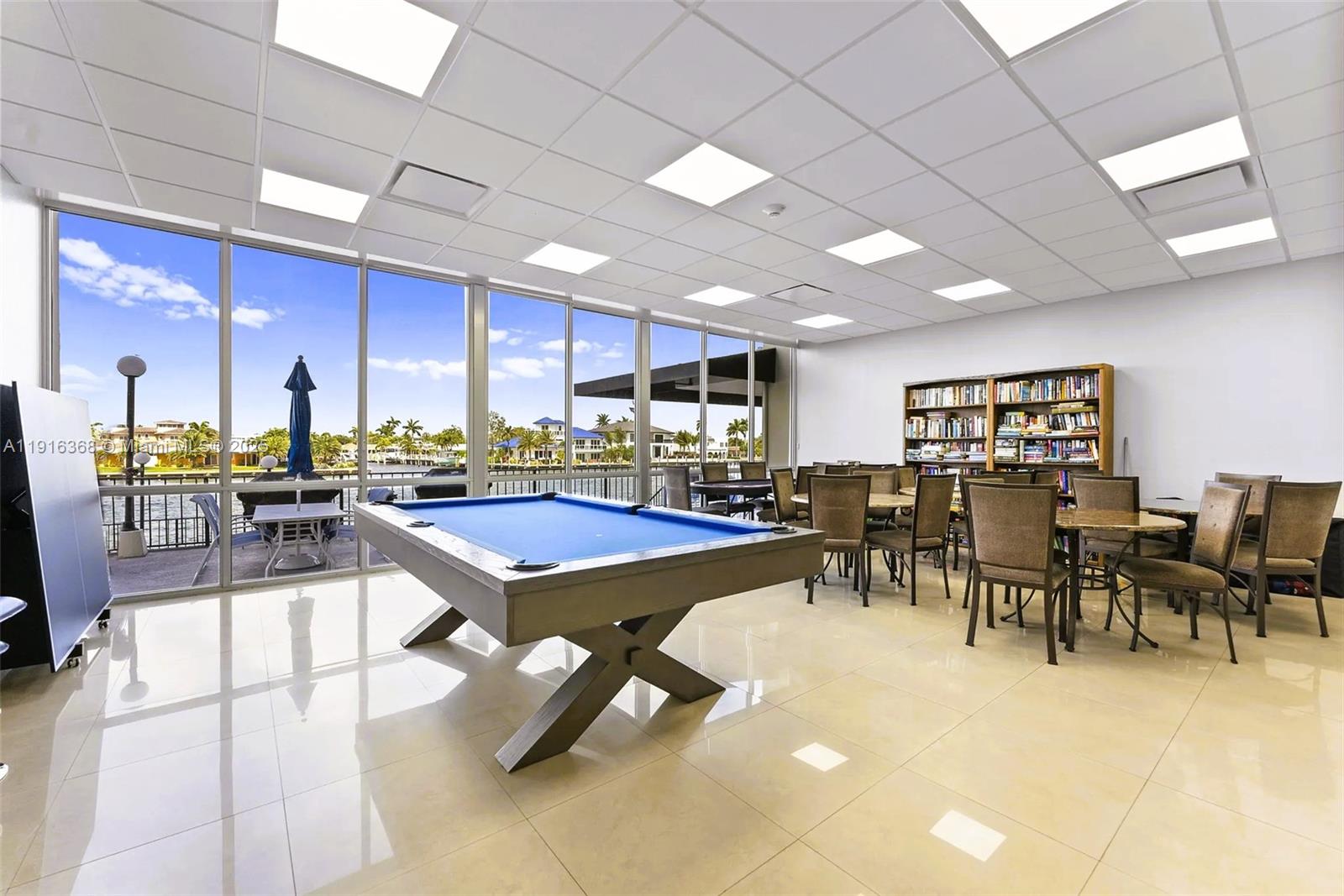 521 North Riverside Drive, Unit 907 Pompano Beach, FL 33062 - Photo 21 of 23 a room with lots of tables a dining table chairs and a kitchen view