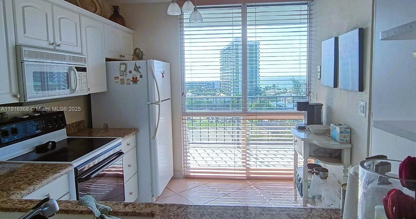 521 North Riverside Drive, Unit 907 Pompano Beach, FL 33062 - Photo 9 of 23 a kitchen with granite countertop a refrigerator and a stove