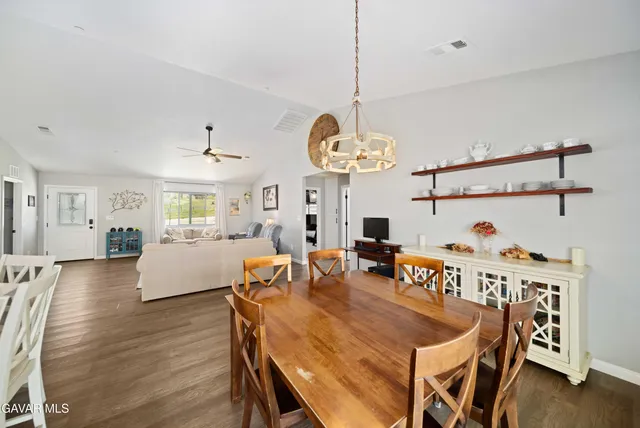 a dining room with furniture a chandelier and wooden floor