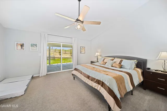a spacious bedroom with a bed and a ceiling fan