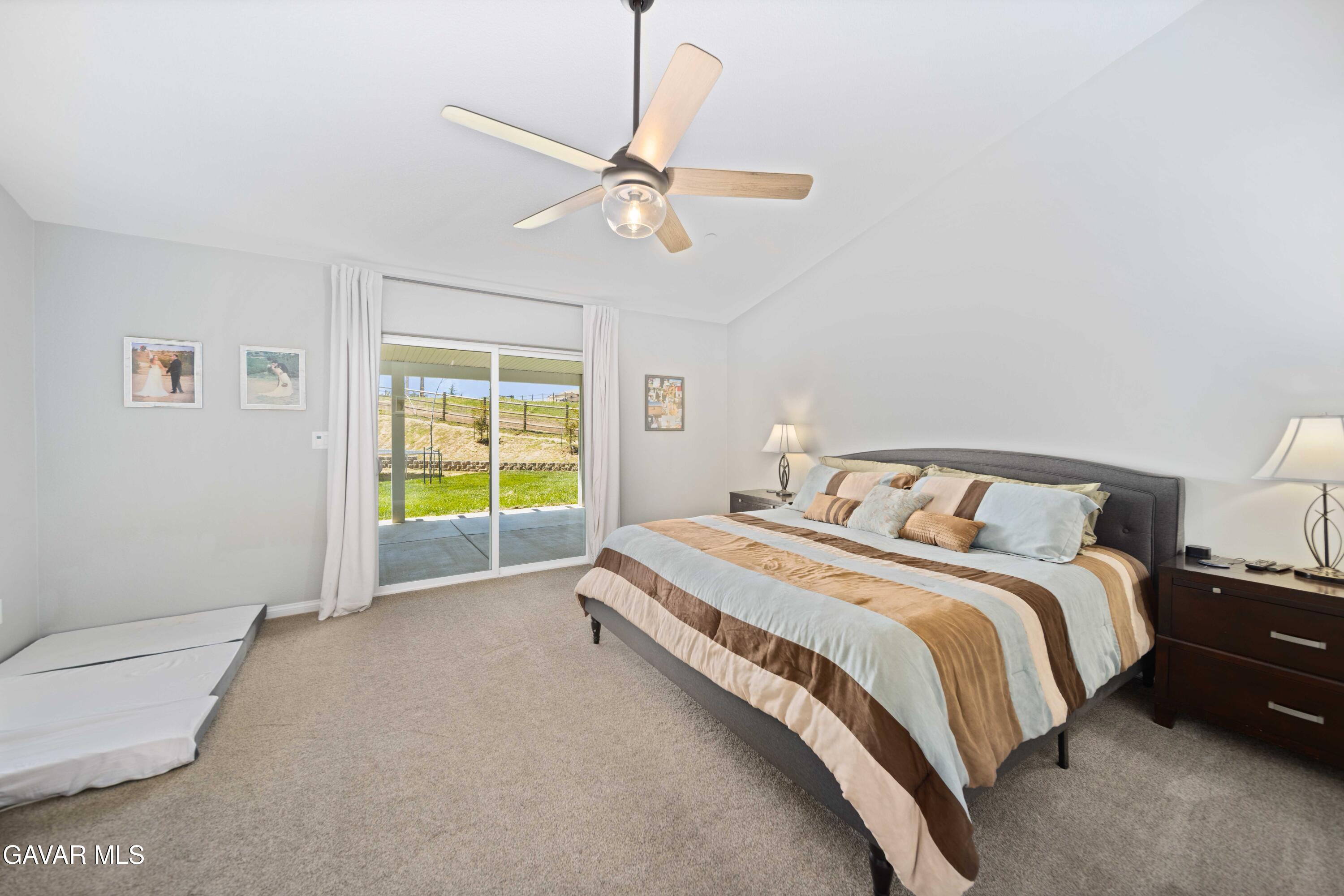 29990 Horsethief Drive Tehachapi, CA 93561 - Photo 15 of 29 a spacious bedroom with a bed and a chandelier