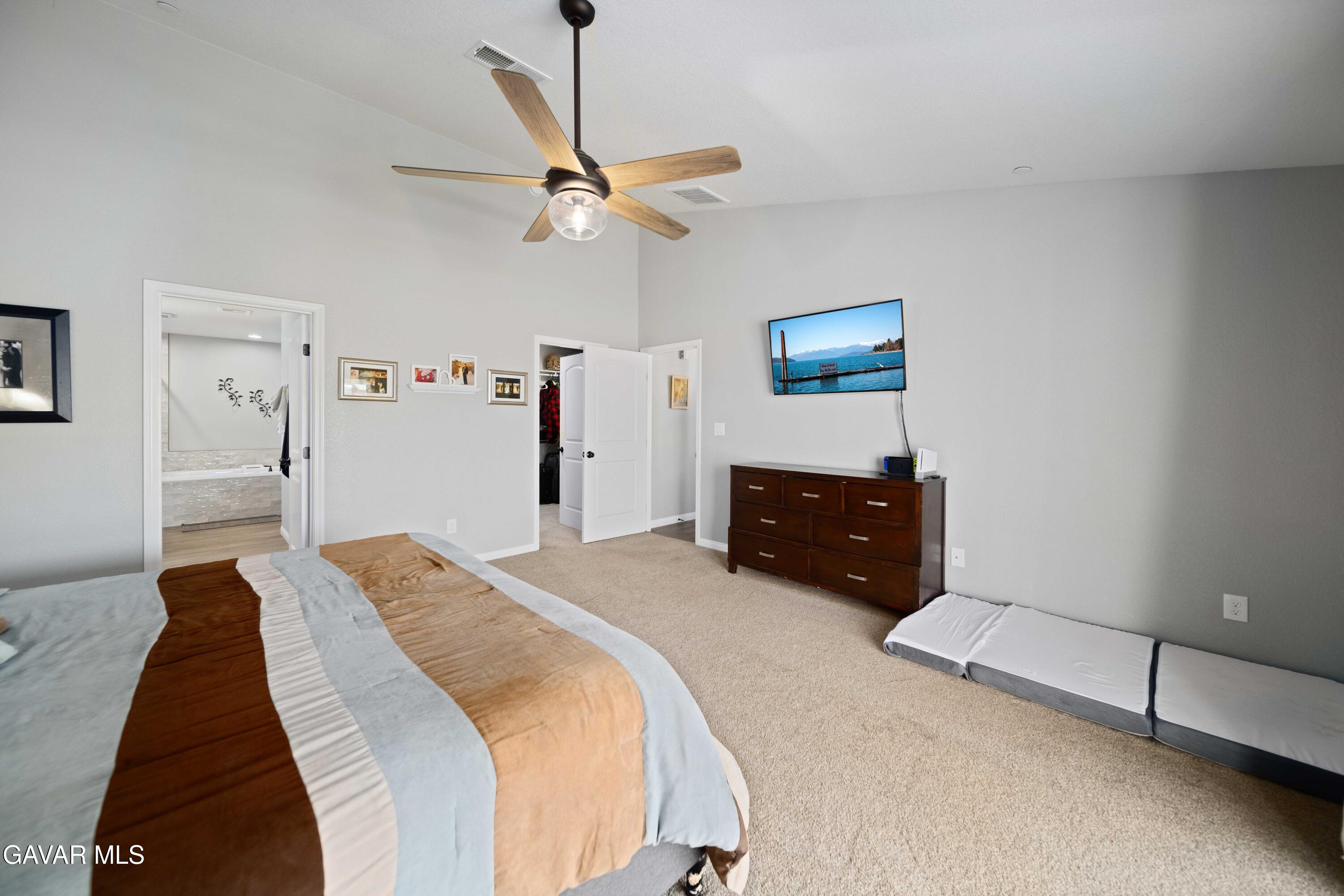 29990 Horsethief Drive Tehachapi, CA 93561 - Photo 16 of 29 a spacious bedroom with a bed and a ceiling fan