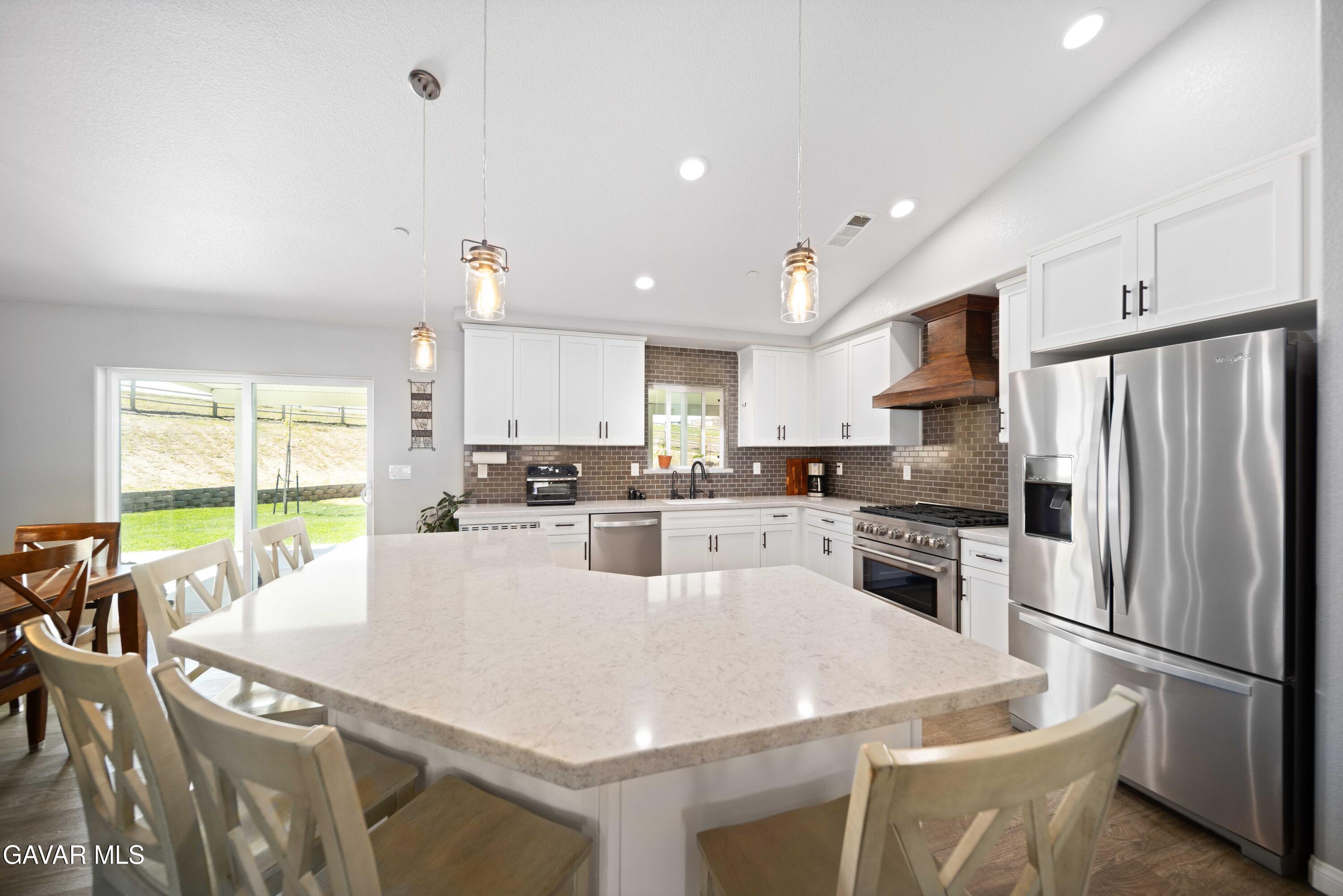 29990 Horsethief Drive Tehachapi, CA 93561 - Photo 8 of 29 a kitchen with stainless steel appliances a refrigerator a stove a sink a dining table and chairs