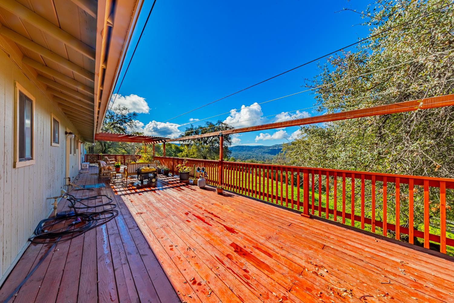 40733 Big Oak Flat Road North Oakhurst, CA 93644 - Photo 51 of 73 a view of a balcony with wooden floor and outdoor seating