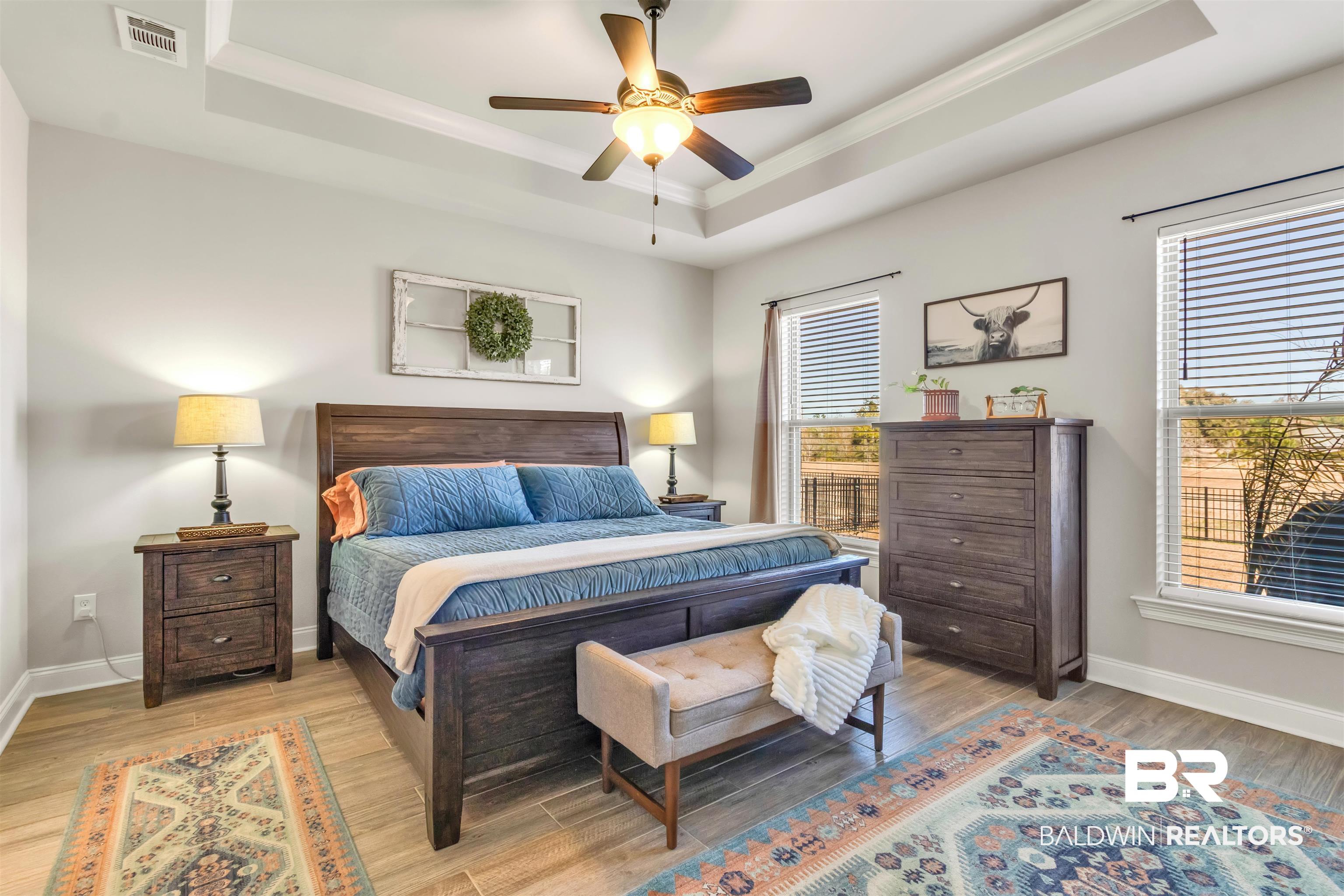 22531 Putter Lane Foley, AL 36535 - Photo 19 of 43 Bedroom with light wood-style floors, ceiling fan, a tray ceiling, and ornamental molding