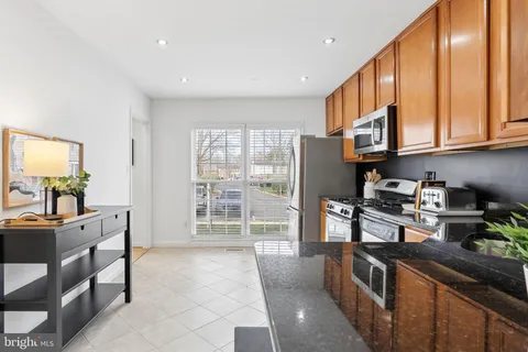 a kitchen with granite countertop a stove cabinets and refrigerator