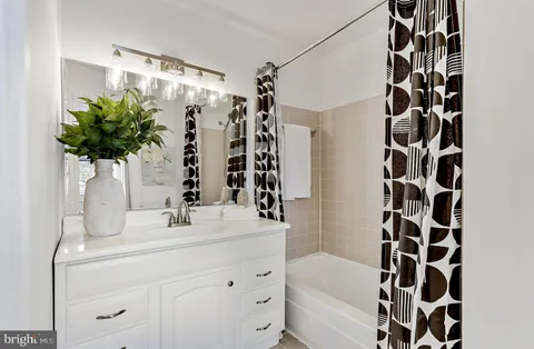 a bedroom with a bed and a table next to a window