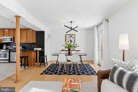 a living room with furniture kitchen view and a potted plant