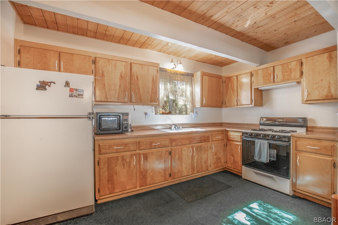 753 Maple Lane Sugarloaf, CA 92386 - Photo 16 of 42 a kitchen with a sink a stove and a refrigerator