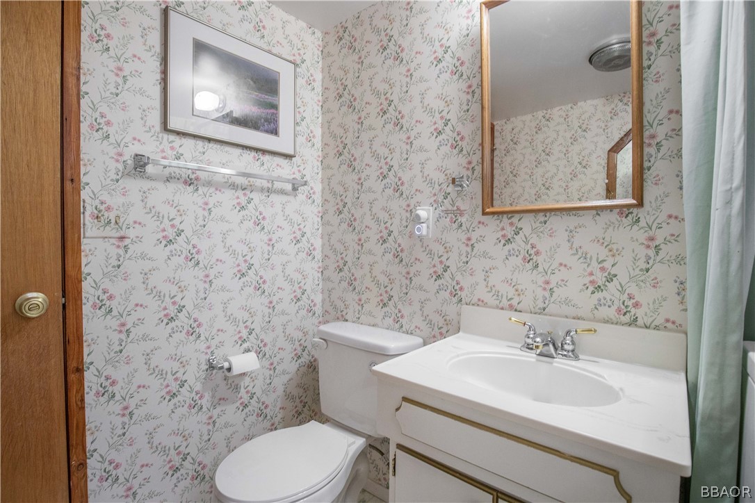 753 Maple Lane Sugarloaf, CA 92386 - Photo 31 of 42 a bathroom with a toilet sink and mirror