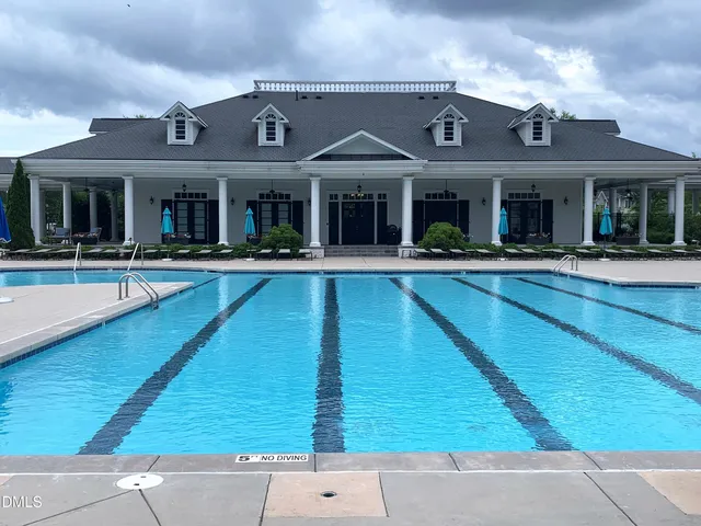 front view of a brick house with a swimming pool
