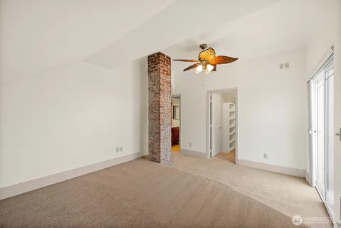 an empty room with closet and a ceiling fan