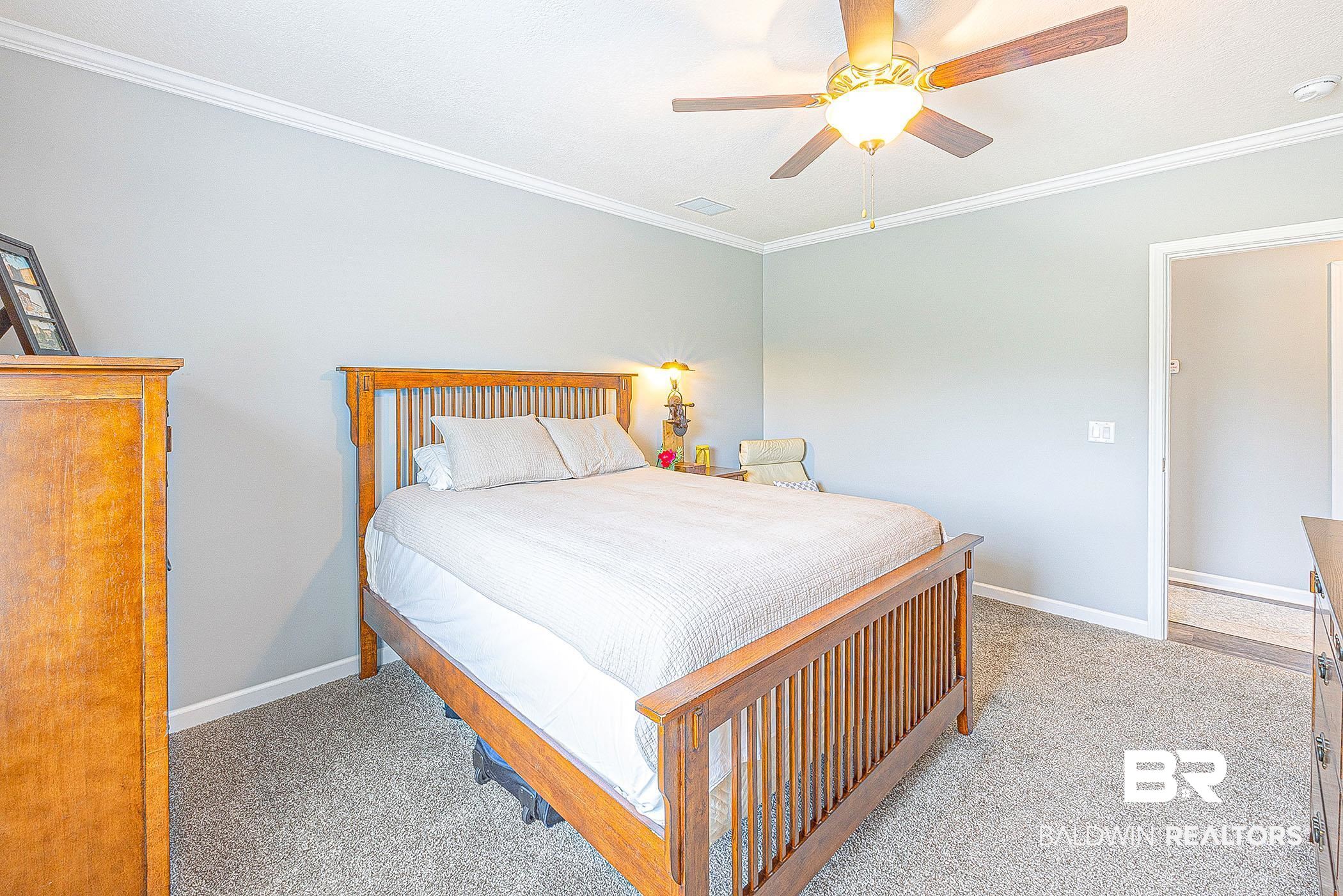 16000 John Bauer Road Summerdale, AL 36580 - Photo 25 of 34 Bedroom with ornamental molding, light carpet, ceiling fan, and baseboards
