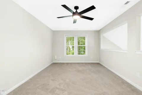 an empty room with a window and a fan
