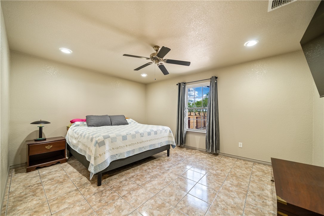 1777 County Road 170 Alice, TX 78332 - Photo 11 of 40 a spacious bedroom with a bed and a ceiling fan