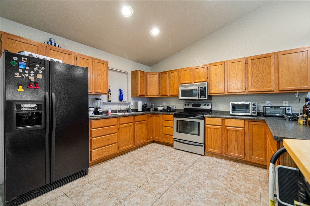 1777 County Road 170 Alice, TX 78332 - Photo 7 of 40 a kitchen with stainless steel appliances granite countertop a refrigerator stove top oven a sink and dishwasher