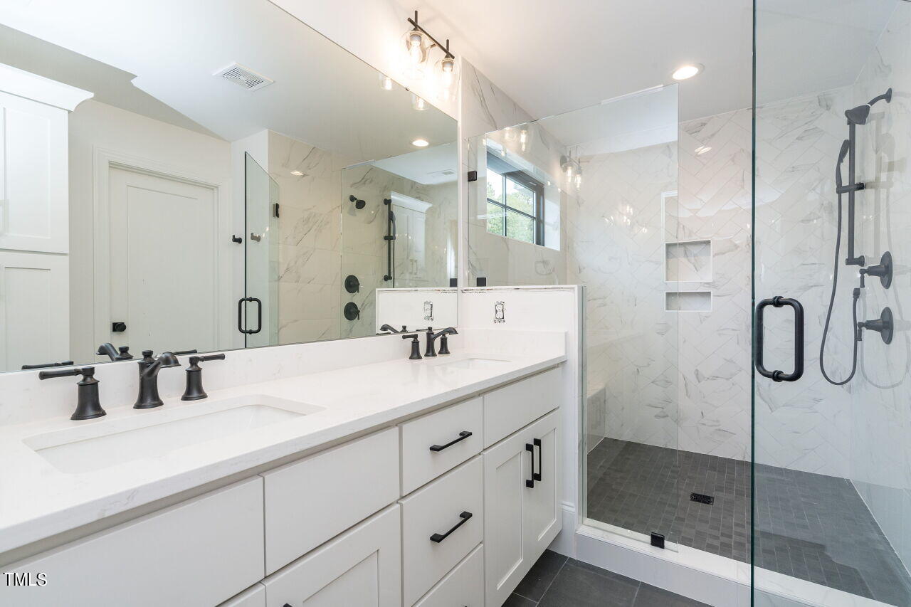 303 Shepherd Street Raleigh, NC 27607 - Photo 23 of 29 a bathroom with a shower sink and mirror