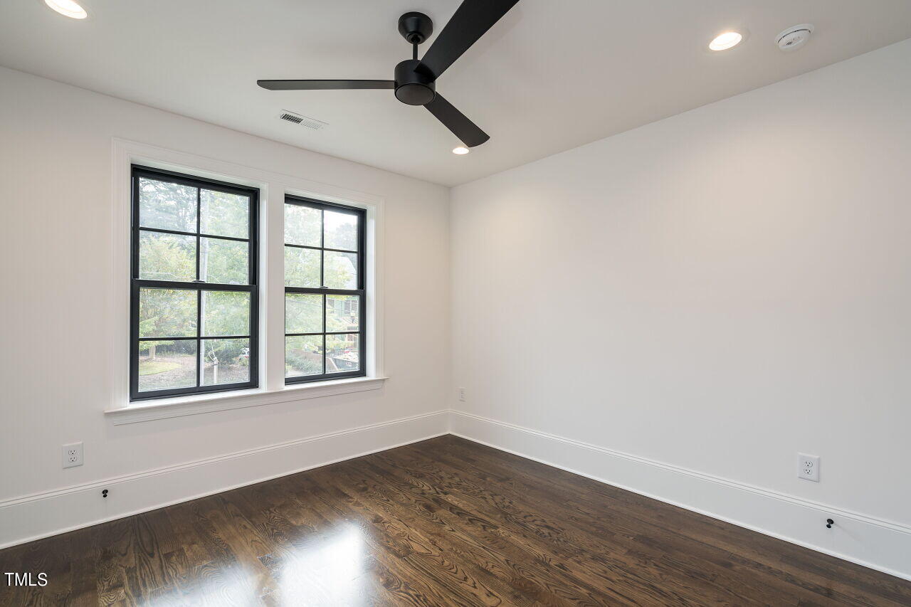303 Shepherd Street Raleigh, NC 27607 - Photo 25 of 29 an empty room with wooden floor and windows
