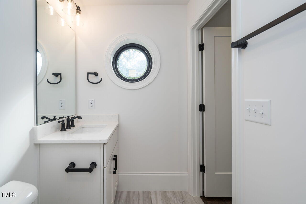 303 Shepherd Street Raleigh, NC 27607 - Photo 26 of 29 a bathroom with a sink mirror vanity and toilet