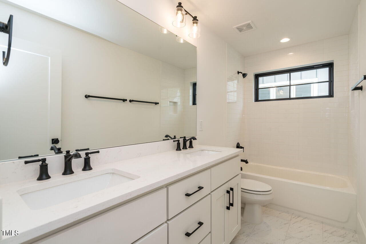 303 Shepherd Street Raleigh, NC 27607 - Photo 27 of 29 a bathroom with a sink a toilet and a bathtub