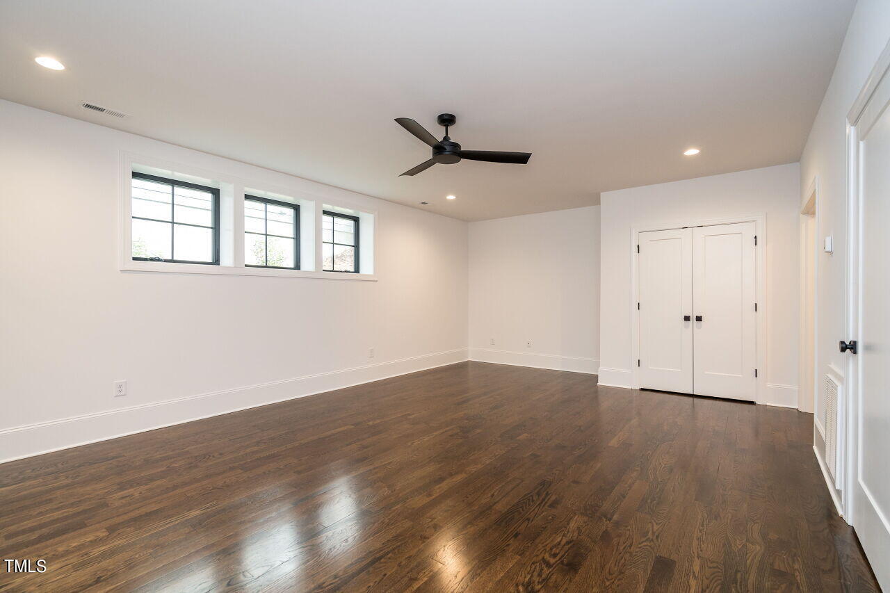 303 Shepherd Street Raleigh, NC 27607 - Photo 28 of 29 a view of a room with wooden floor and a ceiling fan