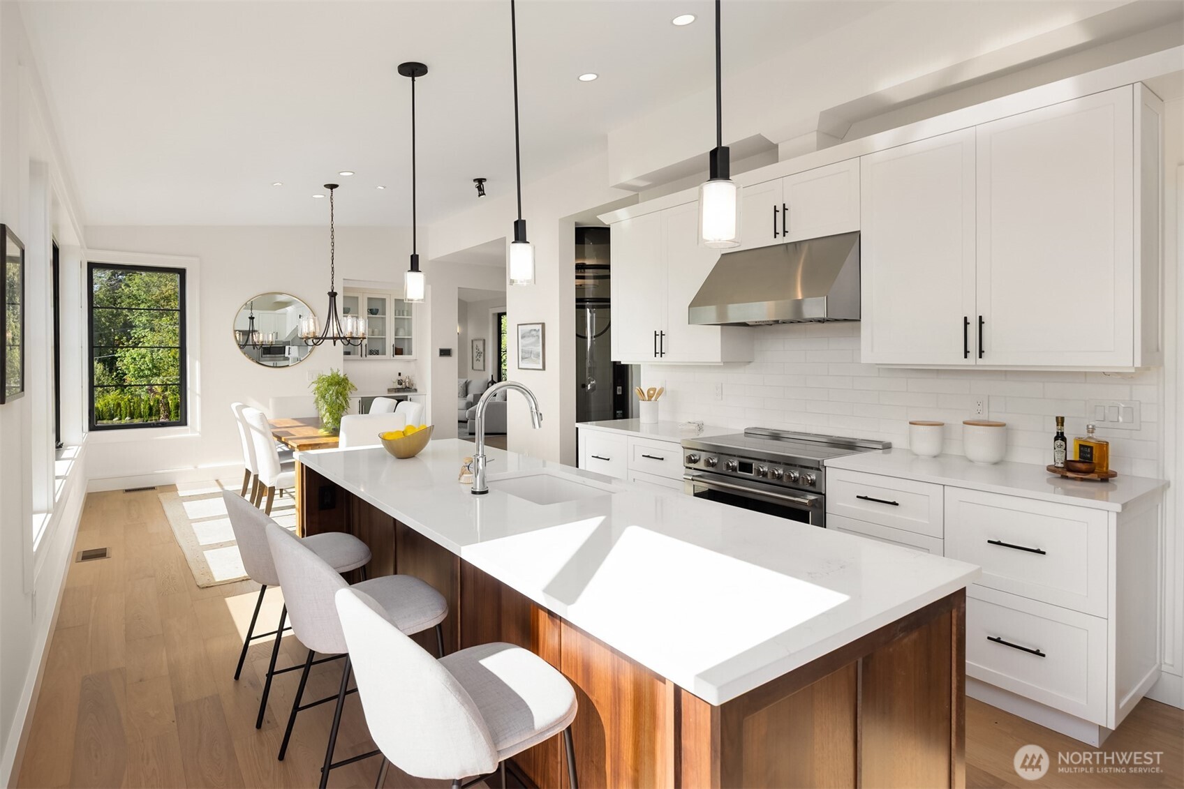 4869 Rosalind Road Northeast Bainbridge Island, WA 98110 - Photo 14 of 40 a kitchen with stainless steel appliances granite countertop a stove a sink a refrigerator a stove a dining table and chairs with wooden floor