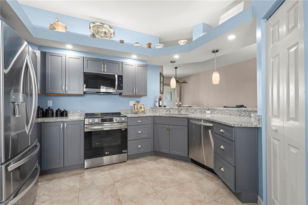 a large kitchen with stainless steel appliances granite countertop a stove and a sink