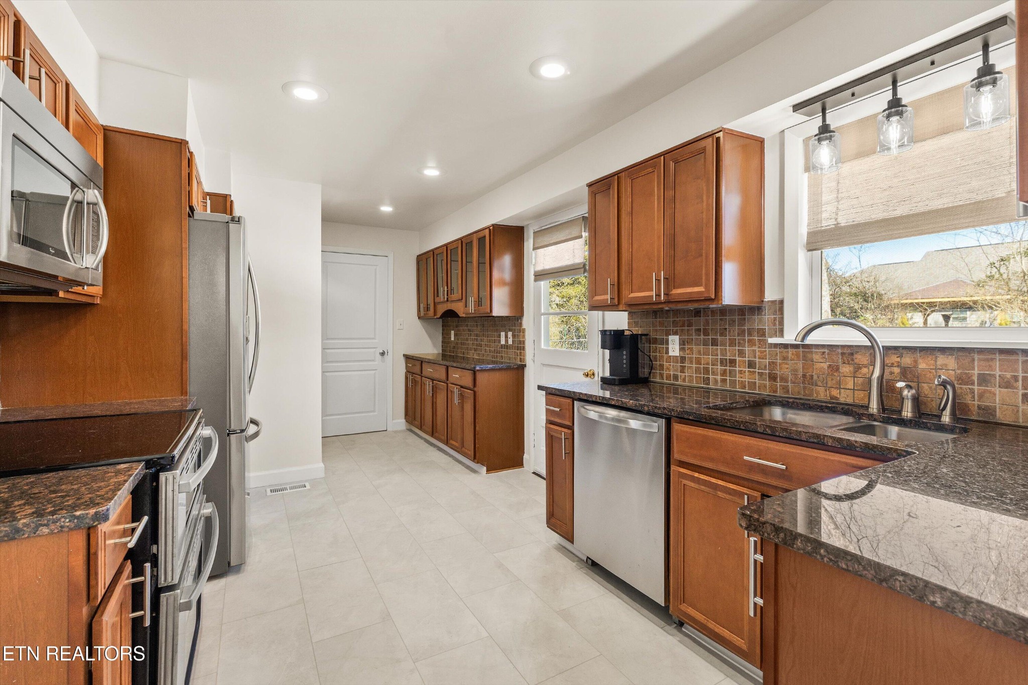 4912 Spring Creek Road Knoxville, TN 37920 - Photo 11 of 29 a kitchen with stainless steel appliances granite countertop a refrigerator sink and cabinets