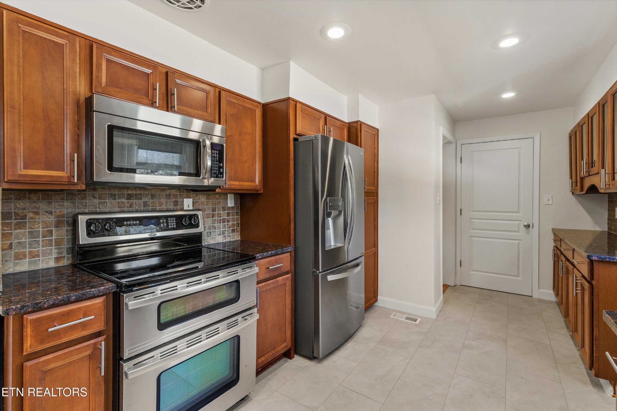 4912 Spring Creek Road Knoxville, TN 37920 - Photo 12 of 29 a kitchen with stainless steel appliances a stove a microwave and a refrigerator