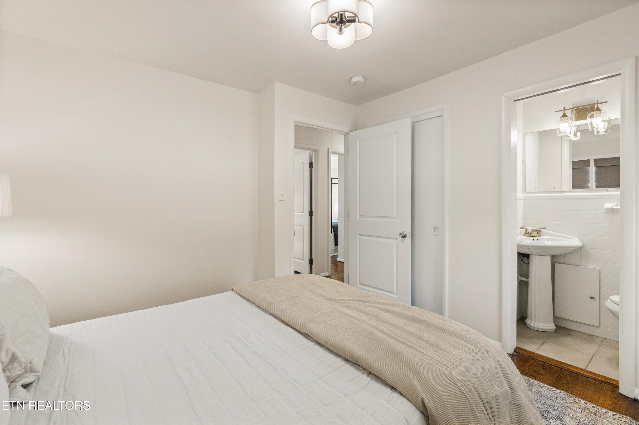 4912 Spring Creek Road Knoxville, TN 37920 - Photo 20 of 29 a bedroom with a bed and a chandelier