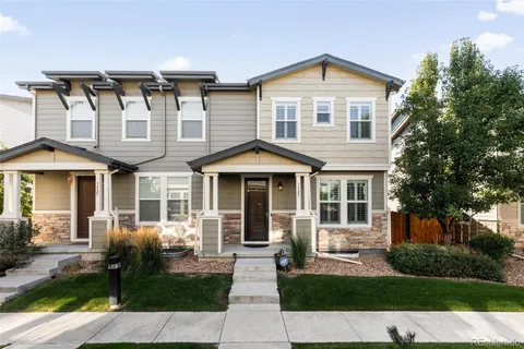 a front view of a house with a yard and potted plants