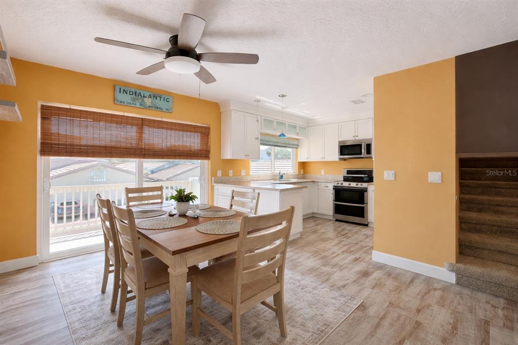 1244 Beachside Lane Indialantic, FL 32903 - Photo 12 of 25 a dining room with furniture a floor to ceiling window and wooden floor
