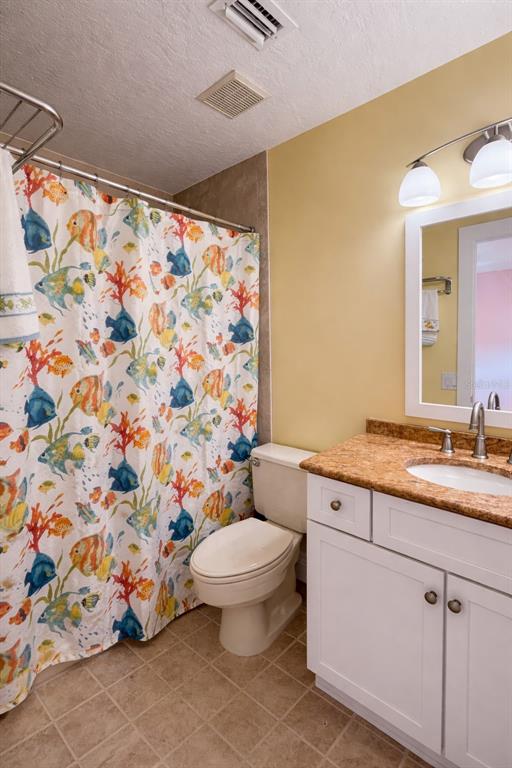 1244 Beachside Lane Indialantic, FL 32903 - Photo 19 of 25 a bathroom with a granite countertop sink mirror vanity and toilet