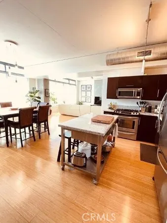 a dining hall with stainless steel appliances kitchen island granite countertop a stove and a sink