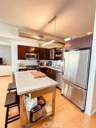 a kitchen with stainless steel appliances granite countertop a refrigerator and a stove top oven